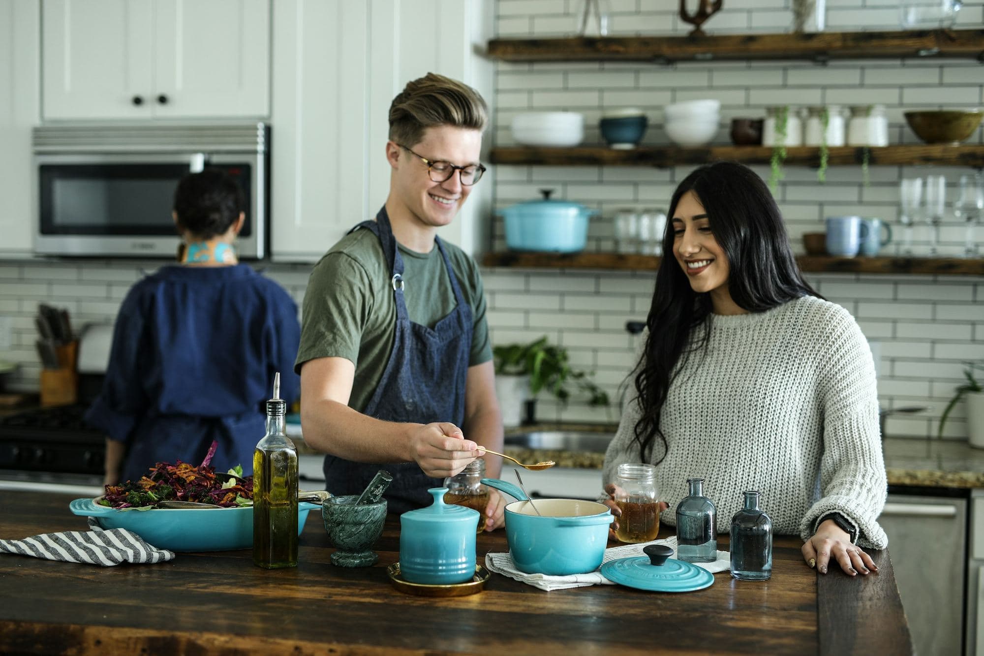 Des colocataires cuisinent ensemble et discutent dans une cuisine ouverte